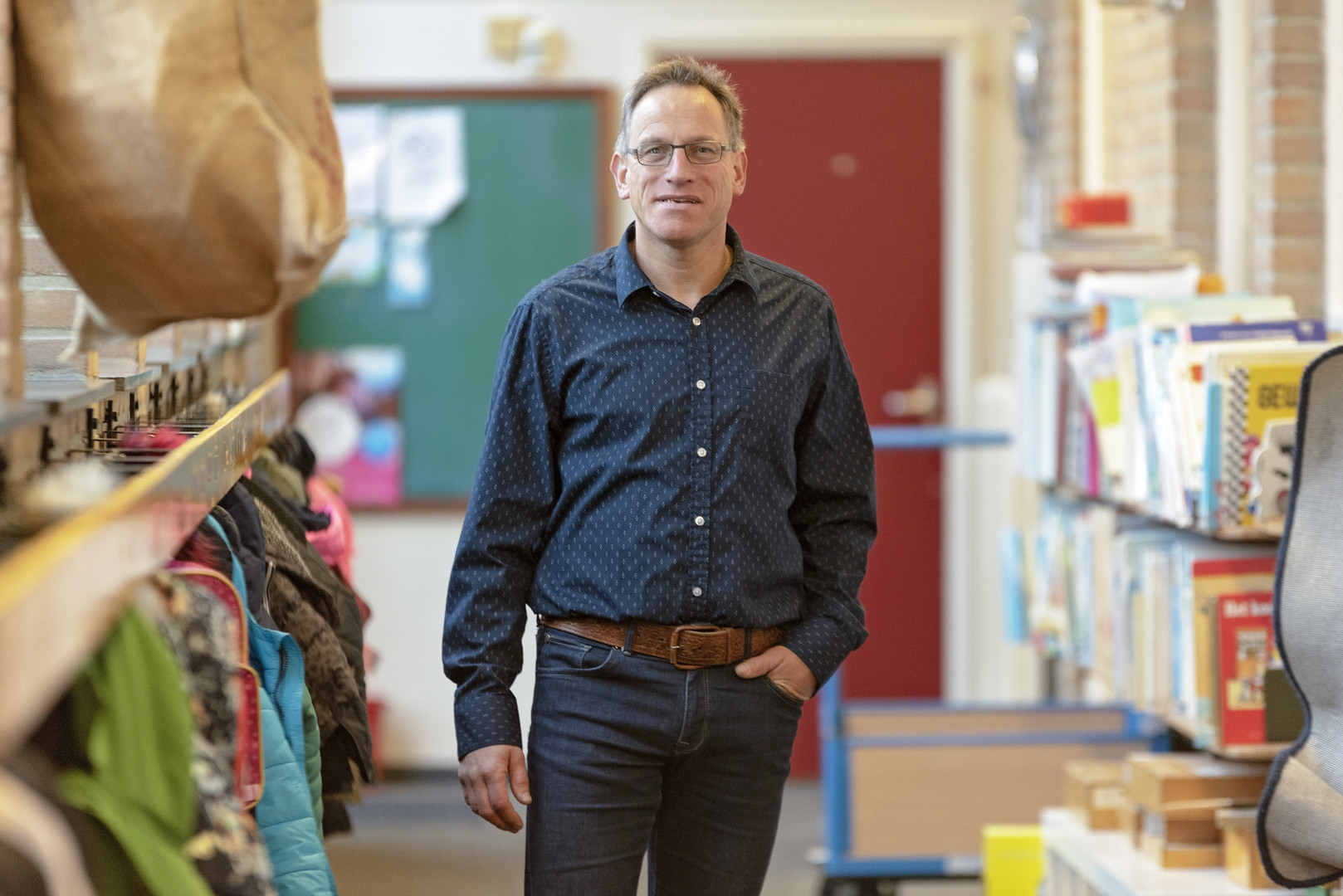 Erik op de gang van de school bij de kapstokken