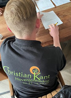 Een close-up foto van Daans handen terwijl hij zijn contract tekent.