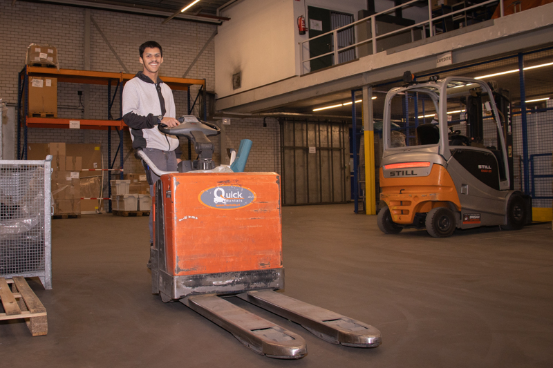 Mylo staat op een elektrische steekwagen in het magazijn