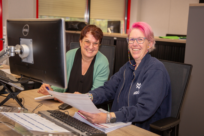 Marielle legt iets uit aan Marielle, ze zitten lachend samen achter de computer van Marielle